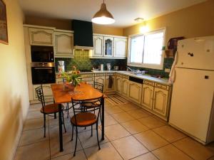een keuken met een tafel en stoelen en een koelkast bij La maison d'audignon in Audignon