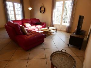 een woonkamer met een rode bank en een tv bij La maison d'audignon in Audignon