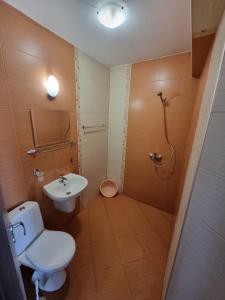 a bathroom with a toilet and a sink and a shower at Стаи за гости Мистрал in Primorsko