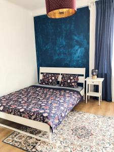 a bedroom with a bed with a blue wall at City Center Apartments Bratislava in Bratislava