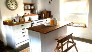 a kitchen with a counter and a clock on the wall at Mansfield Cottage in Kilsby