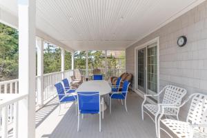 Beach House في Amagansett: شرفة عليها طاولة وكراسي