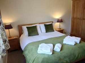 Spacious 4 Bedroom House with Garden and Parking في Ecclesall: غرفة نوم عليها سرير وفوط