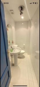 een badkamer met een wastafel, een toilet en een spiegel bij Casa helanna in El Puerto de Santa María