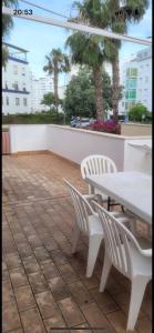 een patio met een tafel en stoelen en palmbomen bij Casa helanna in El Puerto de Santa María
