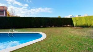 una piscina en un patio con un seto en Sonora Golf and rest apartment, en Santa Cristina d'Aro
