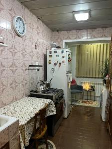 a kitchen with a refrigerator and a table and a clock at Irma's Apartment in Kobuleti