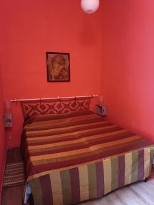 イグレージアスにあるCasa Colombiniの赤い壁のドミトリールームのベッド1台分です。
