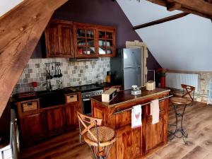 een keuken met houten kasten en een kookplaat met oven bij Les Granges Indigo in Fossemagne