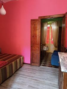 a bedroom with a bed and a pink wall at Casa Colombini in Iglesias