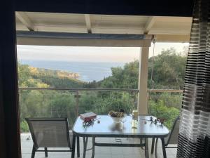 a table and chairs in front of a large window at Anthi's House in Vlachopoulátika