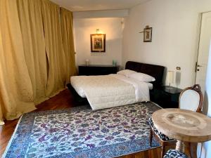 a bedroom with a bed and a table and a rug at B&B Vela Sea in Civitanova Marche