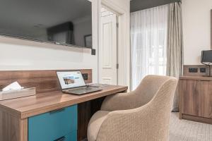a room with a desk with a laptop and two chairs at Mercure Salisbury White Hart Hotel in Salisbury