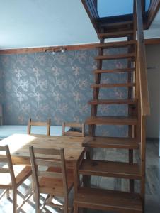 明尼謝克波羅德的住宿－Apartmány Audy，一间带木桌和螺旋楼梯的用餐室