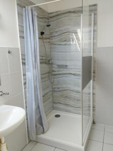 y baño con ducha, aseo y lavamanos. en Apartmány Audy, en Mníšek pod Brdy