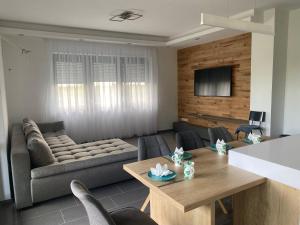 a living room with a couch and a table at Terra Toscana Apartman in Sárvár