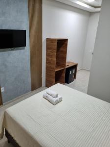 sypialnia z łóżkiem z dwoma ręcznikami w obiekcie PIRANHAS HOTEL w mieście Piranhas