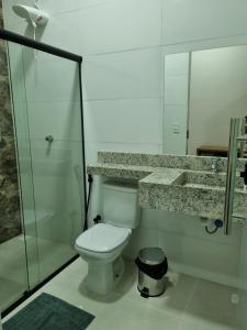 W łazience znajduje się toaleta i przeszklony prysznic. w obiekcie PIRANHAS HOTEL w mieście Piranhas