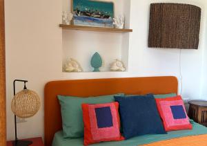 una camera da letto con un letto con cuscini colorati di A' BITTA a Favignana