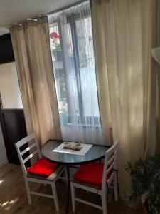 a table with two chairs and a table with a window at Rooms & Apartment Lasta in Split
