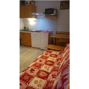 a small room with a bed and a kitchen at L'appartement LES BOSSONS en lisière de forêt dans le chalet Génépi in Arêches