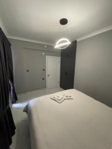 Un dormitorio con una cama blanca con luz. en Continental Trabzon Suite&Apartments, en Trabzon