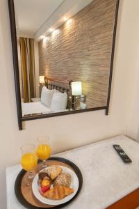 a plate of food on a table with a mirror at Argo Hotel Piraeus in Piraeus