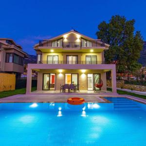 a house with a swimming pool in front of a house at Villa Lina Ölüdeniz/Fethiye in Fethiye