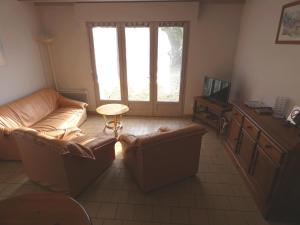 salon z 2 skórzanymi kanapami i telewizorem w obiekcie Gite arriou du bruca w mieście Sort-en-Chalosse