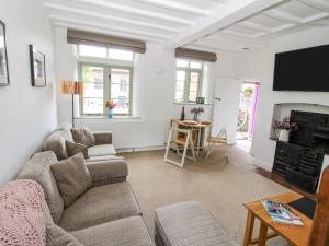 a living room with a couch and a fireplace at Rectory Cottage in Oswestry