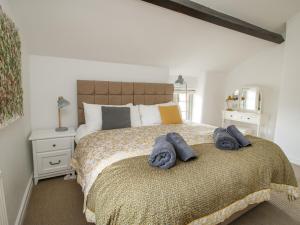 a bedroom with a large bed with towels on it at Rectory Cottage in Oswestry