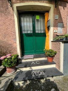 a green door on a house with potted plants at La Maisonette in Sori