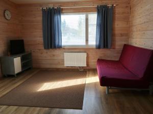 uma sala de estar com um sofá vermelho e uma televisão em SportHome em Rovaniemi