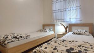 a bedroom with two beds and a window at D & S Family Apartments Budva in Budva