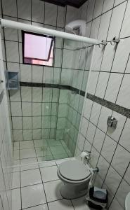 uma casa de banho com um WC e um chuveiro com uma janela em Descanso a 100m do Mar em Itapema