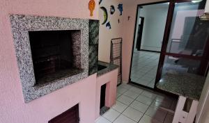 伊塔佩馬的住宿－Descanso a 100m do Mar，客厅设有粉红色墙壁上的壁炉