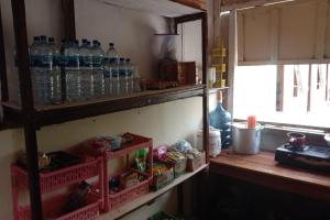 a shelf filled with bottles of water in a kitchen at EXPRESS O 91938 Grace Kost & Hostel in Balangdua