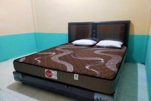 a bed with two pillows on it in a room at EXPRESS O 91938 Grace Kost & Hostel in Balangdua
