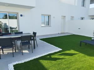 a dining room with a table and green grass at Stella ventis in Marzamemi