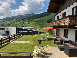 ザールバッハ・ヒンターグレムにあるPanoramaの椅子と傘付きの建物のバルコニー