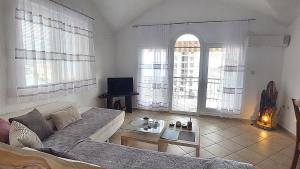 a living room with a couch and some windows at D & S Family Apartments Budva in Budva