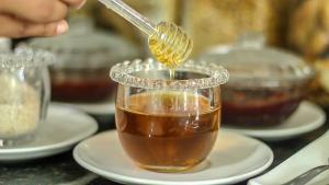 a jar of honey with a spoon in it at Pousada Ponta de Mangue in Maragogi