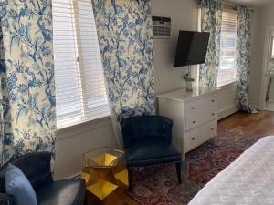 a bedroom with a bed and a chair and a tv at Inkwell Beach Cottage in Oak Bluffs