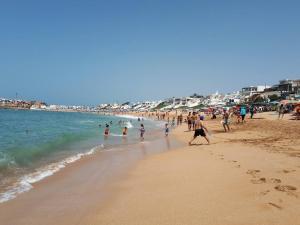 un grupo de personas caminando por una playa en Beautiful Apartment in Costa beach Bouznika, en Bouznika