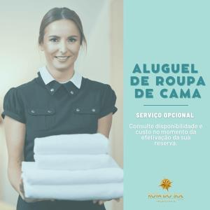 Eine Frau hält einen Stapel Handtücher. in der Unterkunft 020A - Sobrado de 3 quartos para alugar, Bombinhas/SC in Bombinhas