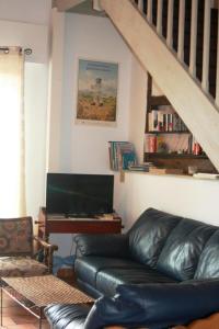 ein Wohnzimmer mit einem Ledersofa und einem Klavier in der Unterkunft Grand rimbez in Poyanne