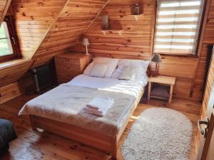a bedroom with a bed in a wooden cabin at Dom na Mazurach - Willa pod Jaworem in Olsztynek