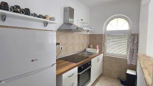 a kitchen with a white refrigerator and a sink at D & S Family Apartments Budva in Budva