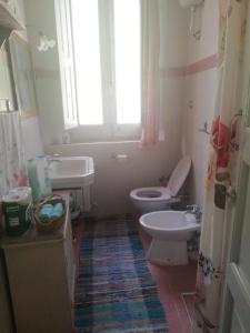 een badkamer met een toilet, een wastafel en een raam bij A zerbi in Cittanova