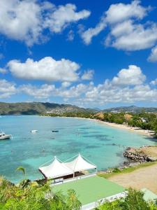 uma vista para uma praia com um barco na água em Kapumati Villa - Évasion en Martinique em Sainte-Anne